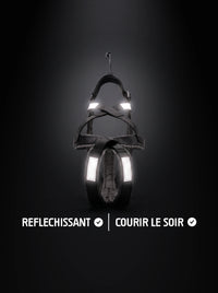 Harnais canicross chien noir avec bandes réfléchissantes qui brillent sous la lumière, pour courir le soir