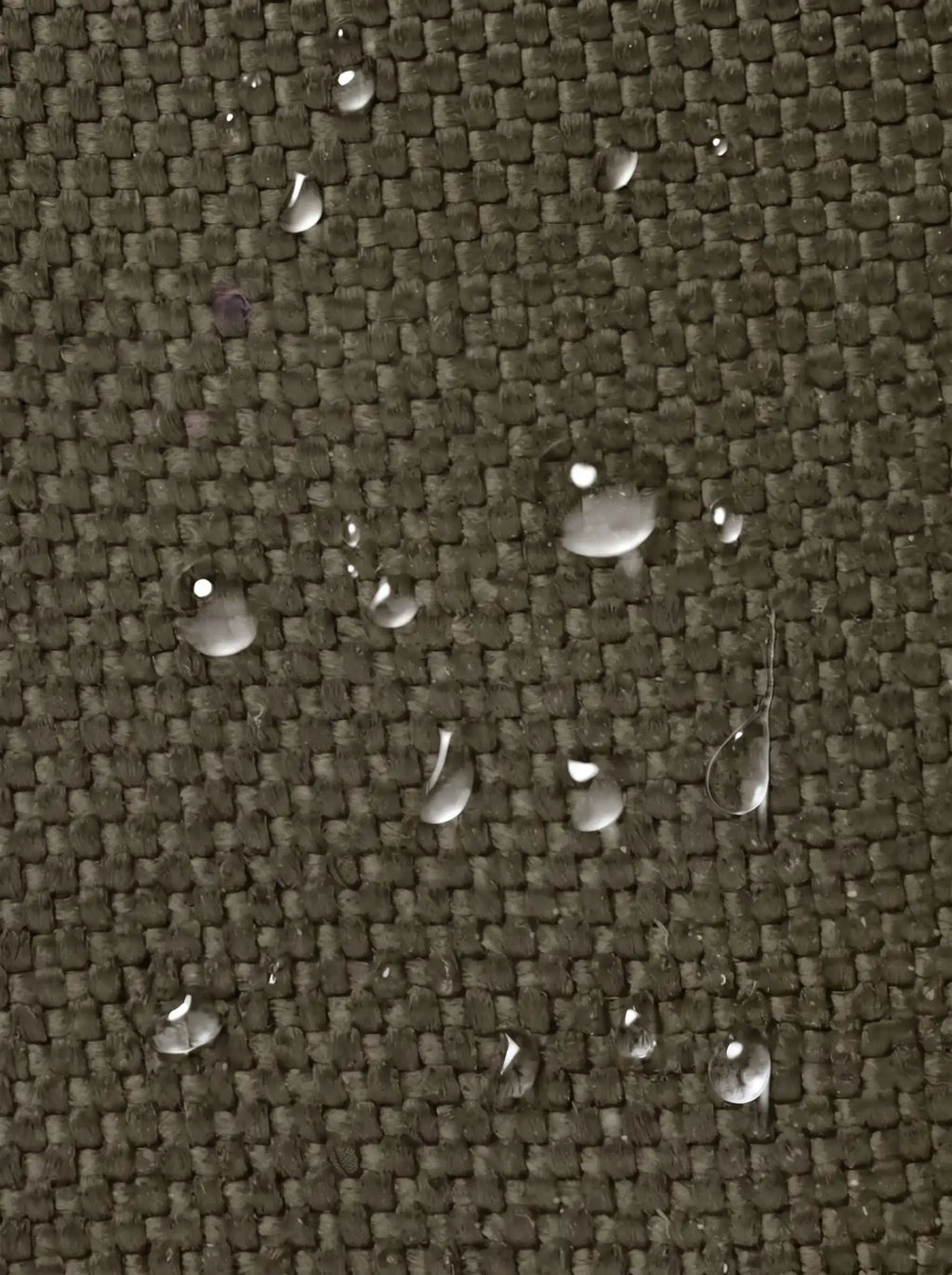 Gros plan du tissu de la pochette tactique MOLLE vert olive avec gouttes d'eau qui perlent en surface
