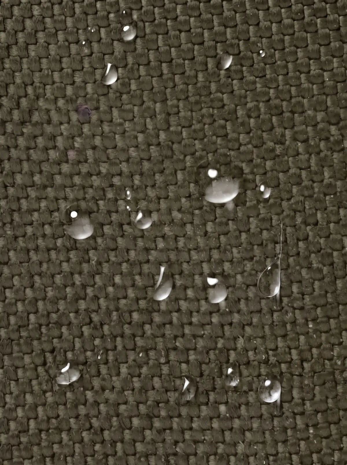 Gros plan du tissu de la pochette tactique MOLLE vert olive avec gouttes d'eau qui perlent en surface